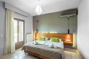 A hotel room with a bed, bedside tables, a ceiling light, and a window with curtains. - Villa Rodi - Four Bedroom Villa, Sleeps 9 (Zakynthos)