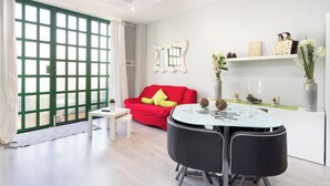 Ein modernes Wohnzimmer mit einem roten Sofa, einem Glastisch und einem weißen Couchtisch.