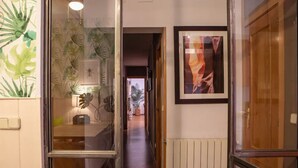 En gang med en glasdør, et indrammet abstrakt billede og en radiator.