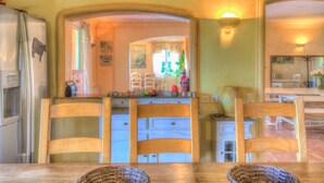 A kitchen with wooden chairs, a dining table, and a refrigerator. -  The Vignaux bastide (Grimaud)
