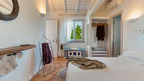 Une chambre à coucher avec un lit, un fauteuil suspendu, une armoire et une fenêtre avec des rideaux.