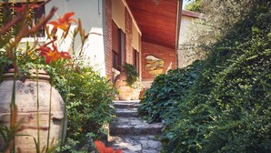 A stone staircase leading to a building with a wooden roof and a brick wall. - Le Balze Charming Apartment in villa, private garden, 10 min from Perugia Centre (Perugia)