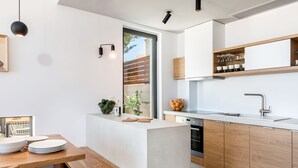 Une cuisine moderne avec des meubles en bois, un four encastré et un plan de travail doté d’un évier.