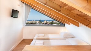 Une chambre avec un plafond en bois, une grande fenêtre donnant sur la ville et deux lits.