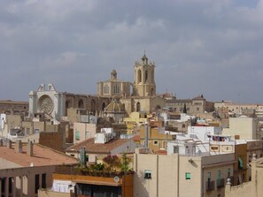 Una chiesa storica con un campanile imponente e un'ampia finestra circolare, circondata da edifici residenziali addossati.