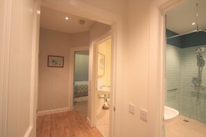 Een bad/douchecombinatie, een haardroger, handdoeken, zeep