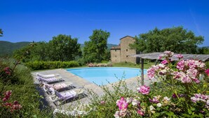 A pool with lounge chairs, a stone building, and lush greenery. - Wonderful private villa for 16 people with WIFI, private pool and TV (Arezzo)