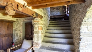 A stone staircase leading to a wooden door, a bench, and baskets on the ceiling. - Wonderful private villa for 16 people with WIFI, private pool and TV (Arezzo)