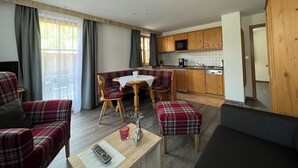 Una sala de estar moderna con comedor, muebles de madera y una cocina con microondas.