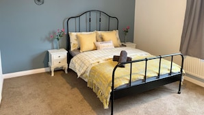 A bedroom with a bed, nightstands, a wall-mounted bicycle decoration, and a window with curtains. - Gordon House. (Kettering)