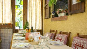 A dining table set with plates, cutlery, and wine glasses, with a sign reading 'Turismo La Roca'.