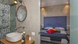 A bathroom with a round sink, a mirror, and a hanging light fixture. - Mediceo 42 - Deluxe Double Room (Pisa)