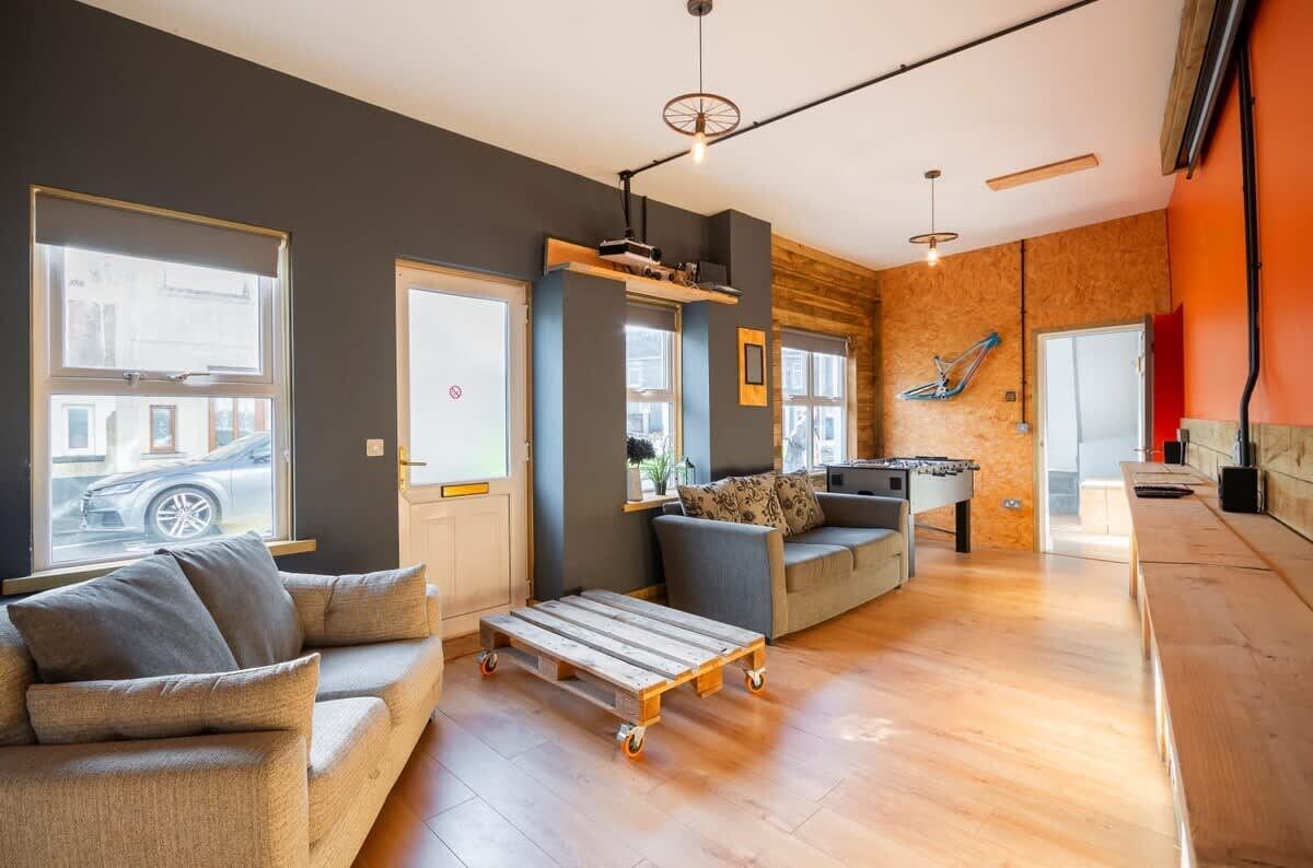 Un salon moderne avec un canapé, une table basse et un baby-foot.
