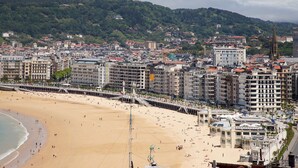 A coastal cityscape with a sandy beach, a promenade, and a prominent church spire. - Villa Baena by FeelFree Rentals (San Sebastián)