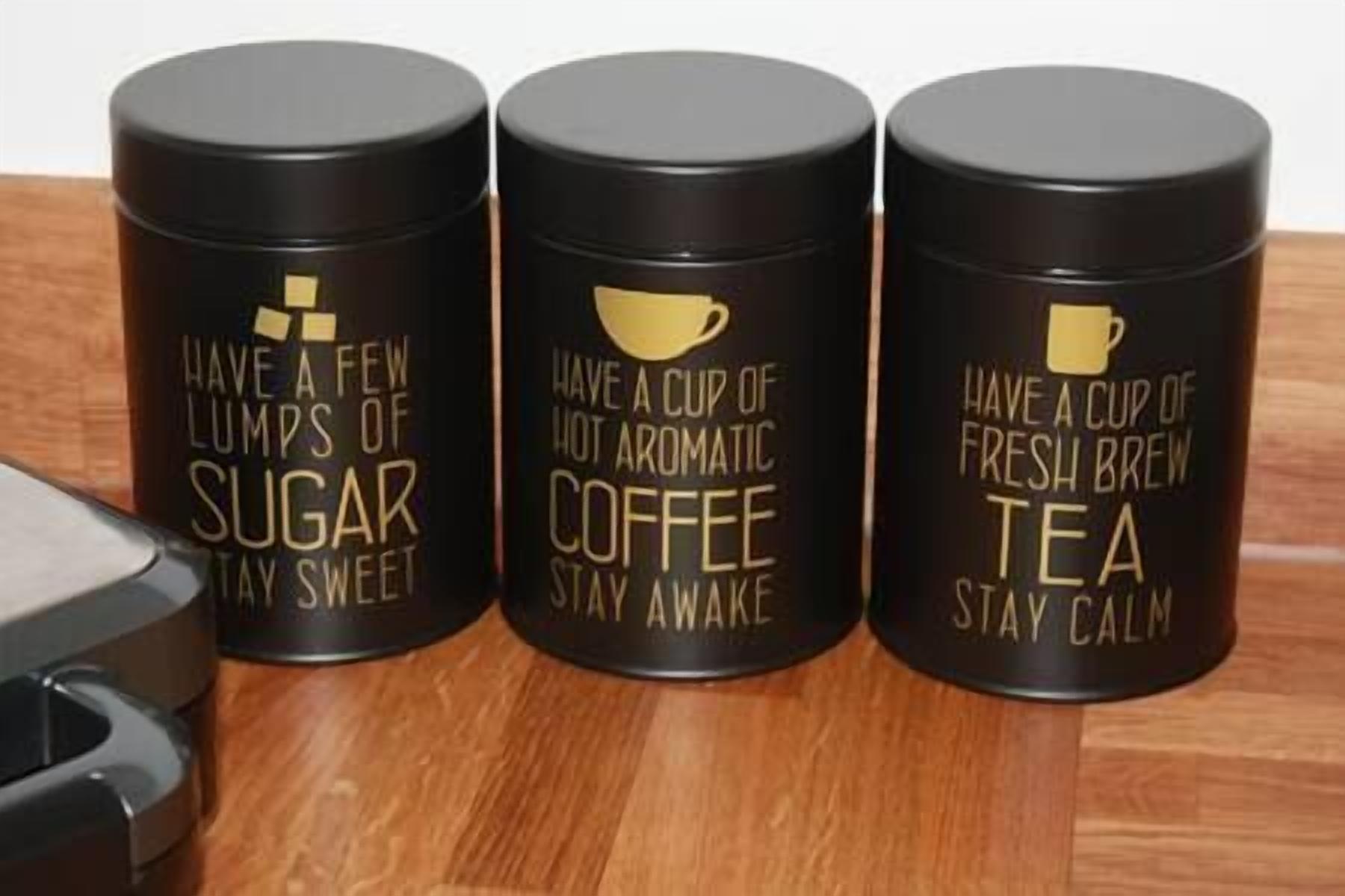 Three black containers with motivational quotes on them.