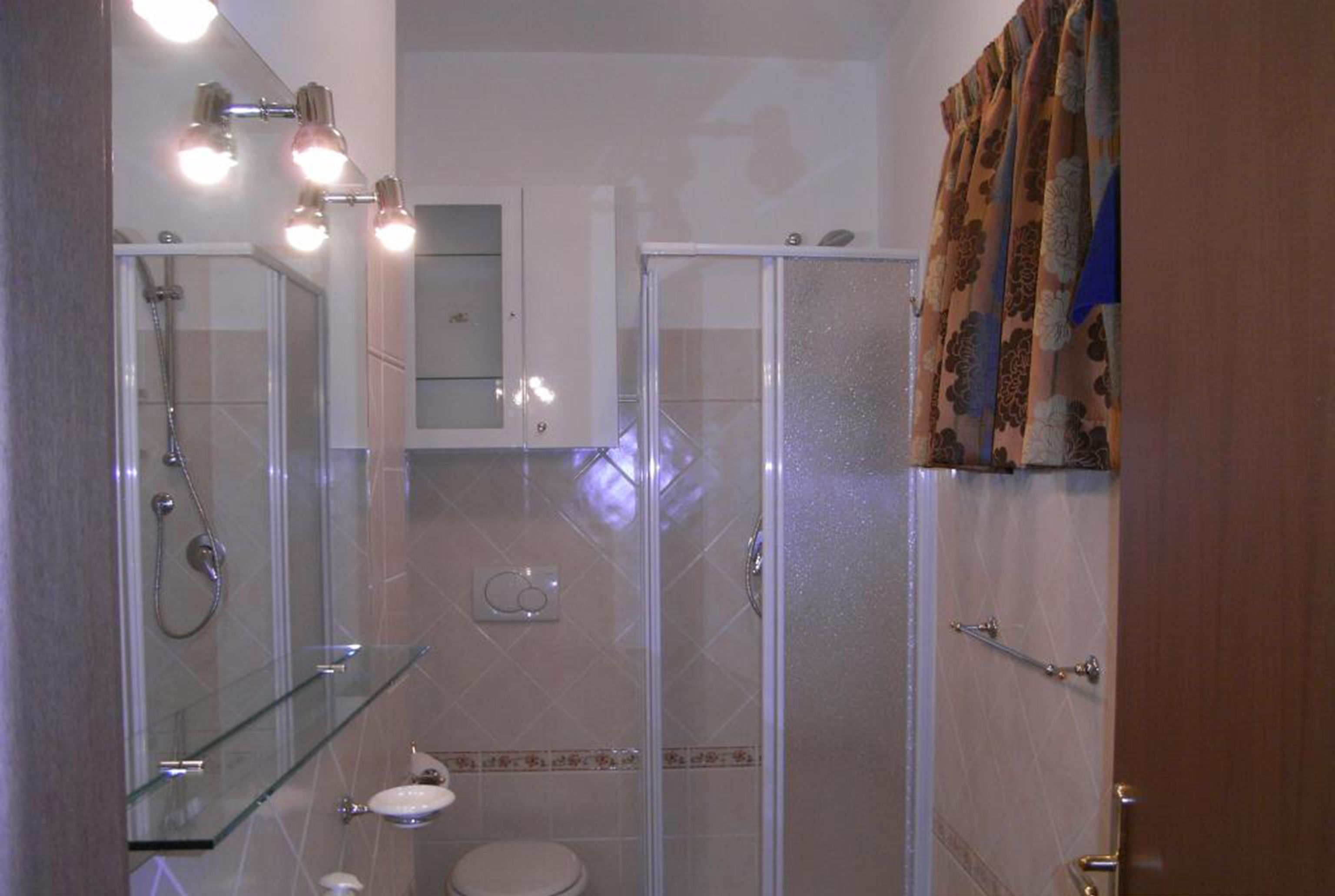 Une salle de bain moderne avec une douche à parois de verre, un lavabo blanc et des toilettes.