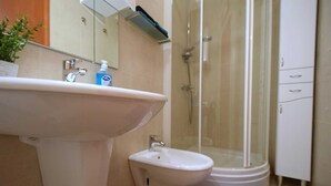 Un baño con lavabo, bidé y ducha.