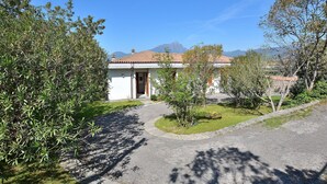 Ein Haus mit Ziegeldach, einer Haustür und einem kleinen Garten.