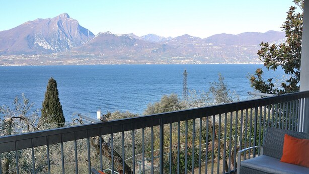Ein Balkon mit Blick auf einen See und Berge.