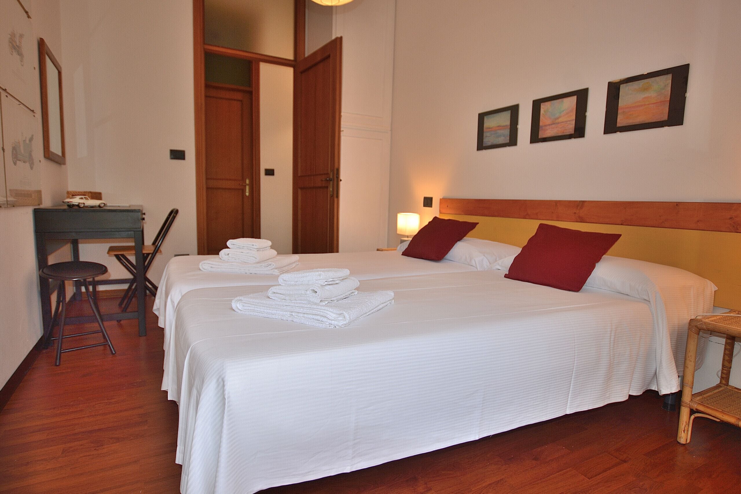 A hotel room with two beds, a desk, and a chair.