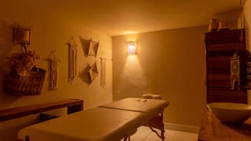Simple, functional space with a single bed, woven wall hangings, and a wooden shelf.