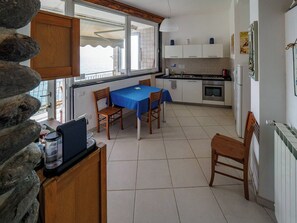 Cocina compacta con zona de comedor, vistas por una ventana y un revestimiento de pared de piedra.