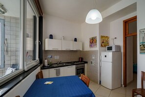 Une cuisine compacte comprenant une table à manger, un réfrigérateur et une fenêtre donnant sur un beau paysage.