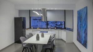 Une cuisine moderne avec un coin repas, de grandes fenêtres et une vue sur la ville.
