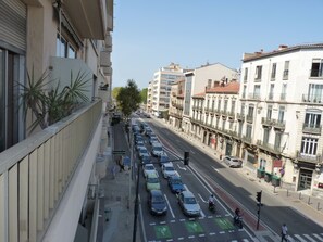 Straßenansicht mit parkenden Autos und einer Fußgängerampel.