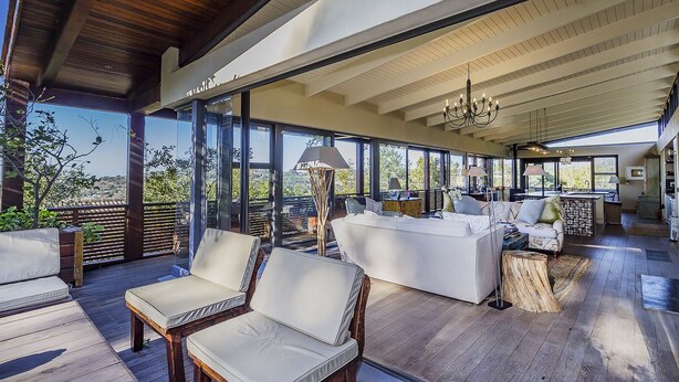 A spacious indoor area with a wooden deck, large windows, and a modern kitchen. - TABLE MOUNTAIN VILLA (Newlands)