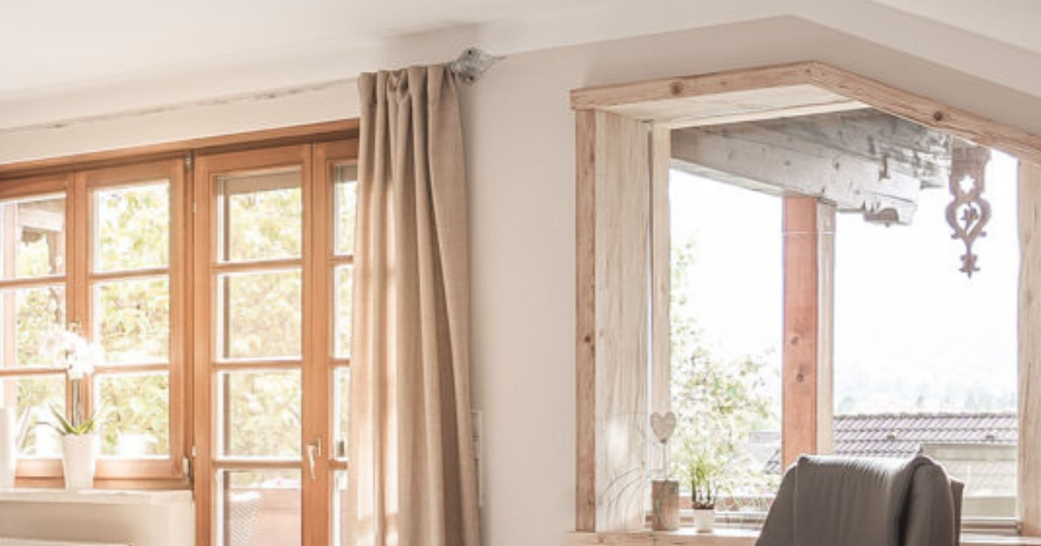 A room with large windows, a wooden ceiling, and a view of the outdoors.