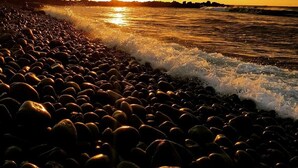 A beach with pebbles and waves at sunset. - A House Between Mountains and Coast in a Beautiful and Quiet sea Village (Skagaströnd)