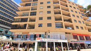 Un immeuble à plusieurs étages doté de balcons et abritant un restaurant appelé « El Chiriguito » au rez-de-chaussée.