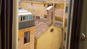 A view through a window of a multi-story building with balconies and a tiled roof. - Sistina House near Spanish Steps (Roma)