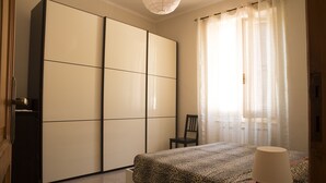 A bedroom with a bed, a chair, a wardrobe, and a lamp. - La Casa della Posta (Brizzolara, Borzonasca, Genova, Italia)