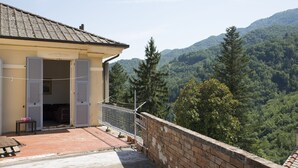 A building with a balcony overlooking a forested valley. - La Casa della Posta (Brizzolara, Borzonasca, Genova, Italia)