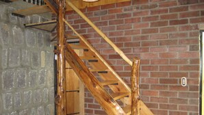 A wooden staircase with a brick wall background.