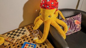 A plush toy octopus on a chair with a checkered board game and a toy with colorful buttons. - Camaella Luxury Studio (Vernazza)
