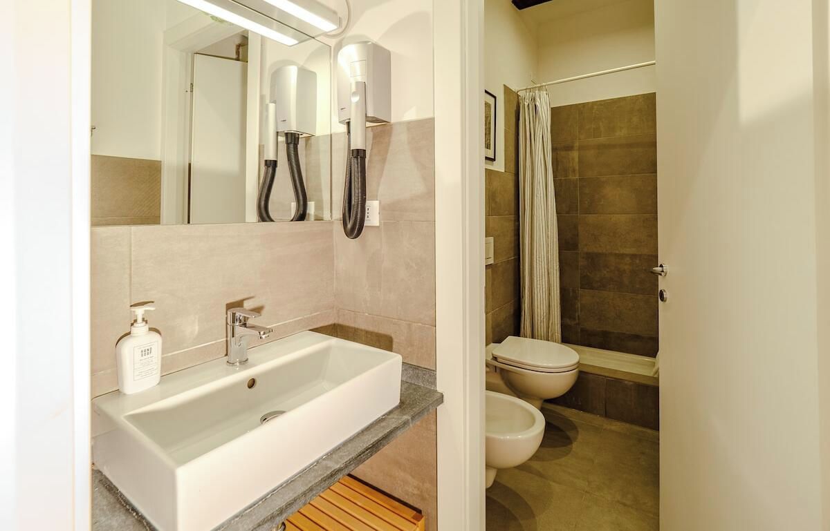 Un bagno moderno con un lavandino grande, un water e uno spazio doccia.