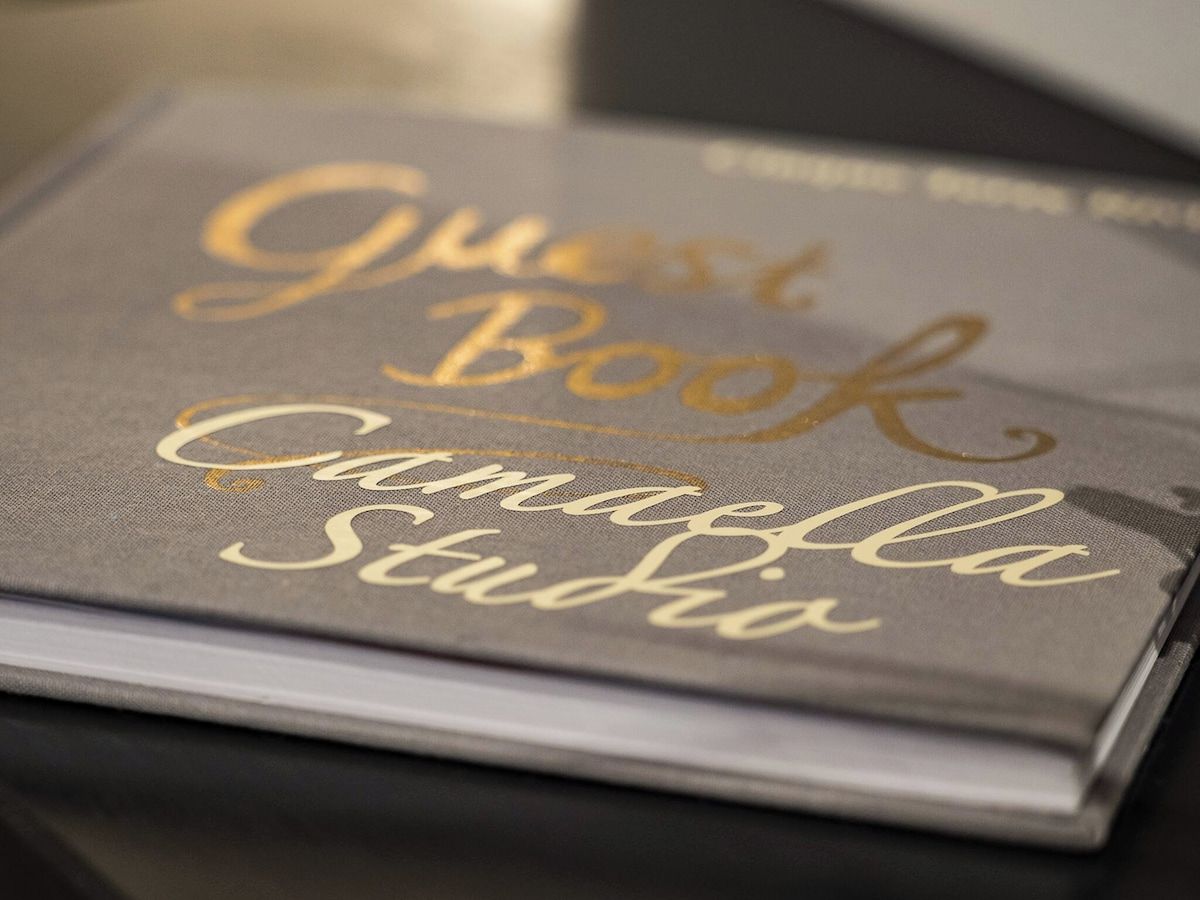 A book titled 'Guest Book' with 'Camilla Studio' written on the cover.