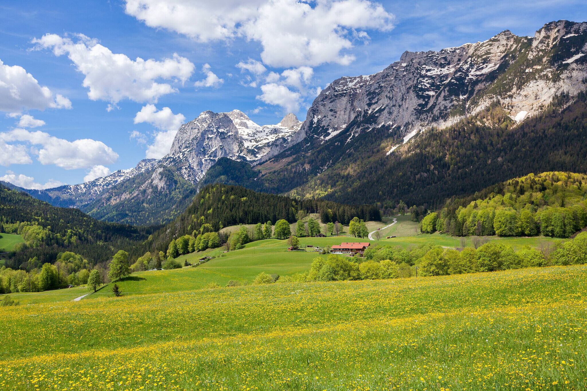 A mountainous landscape with a red-roofed building in a valley.