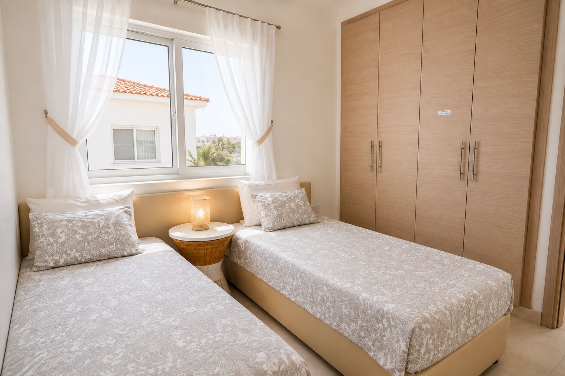 Una camera da letto con due letti singoli, un comodino con una lampada e un armadio.