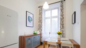 A modern kitchen with a Bosch refrigerator, a wooden cabinet, and a dining table with chairs.