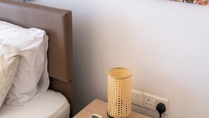 A bedroom with a bed, a bedside table with a lamp, a remote control, and a wall painting of a deer. - Narcissos Villa 3 - Three Bedroom Villa, Sleeps 8 (Protaras)