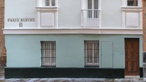 Un edificio con tre piani, ognuno con un balcone. Sulla facciata è visibile il nome 