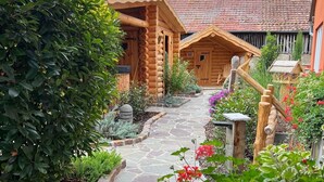 Eine Blockhütte mit einem Steinweg, der zu einer Holzterrasse führt.