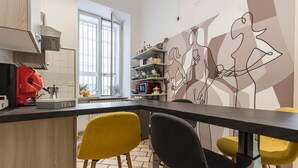 Une cuisine moderne dotée d’une machine à café intégrée, d’une fenêtre offrant une belle vue et d’un mur orné d’œuvres d’art abstrait.