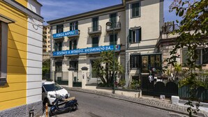 Un bâtiment sur lequel on peut lire les inscriptions « Forza Napoli » et « Scusate Il Ritardo, Ricomincio Da... ».