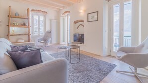 A modern living room with a sofa, armchairs, a TV, and a fireplace. - Elizabeth House Varenna (Varenna)