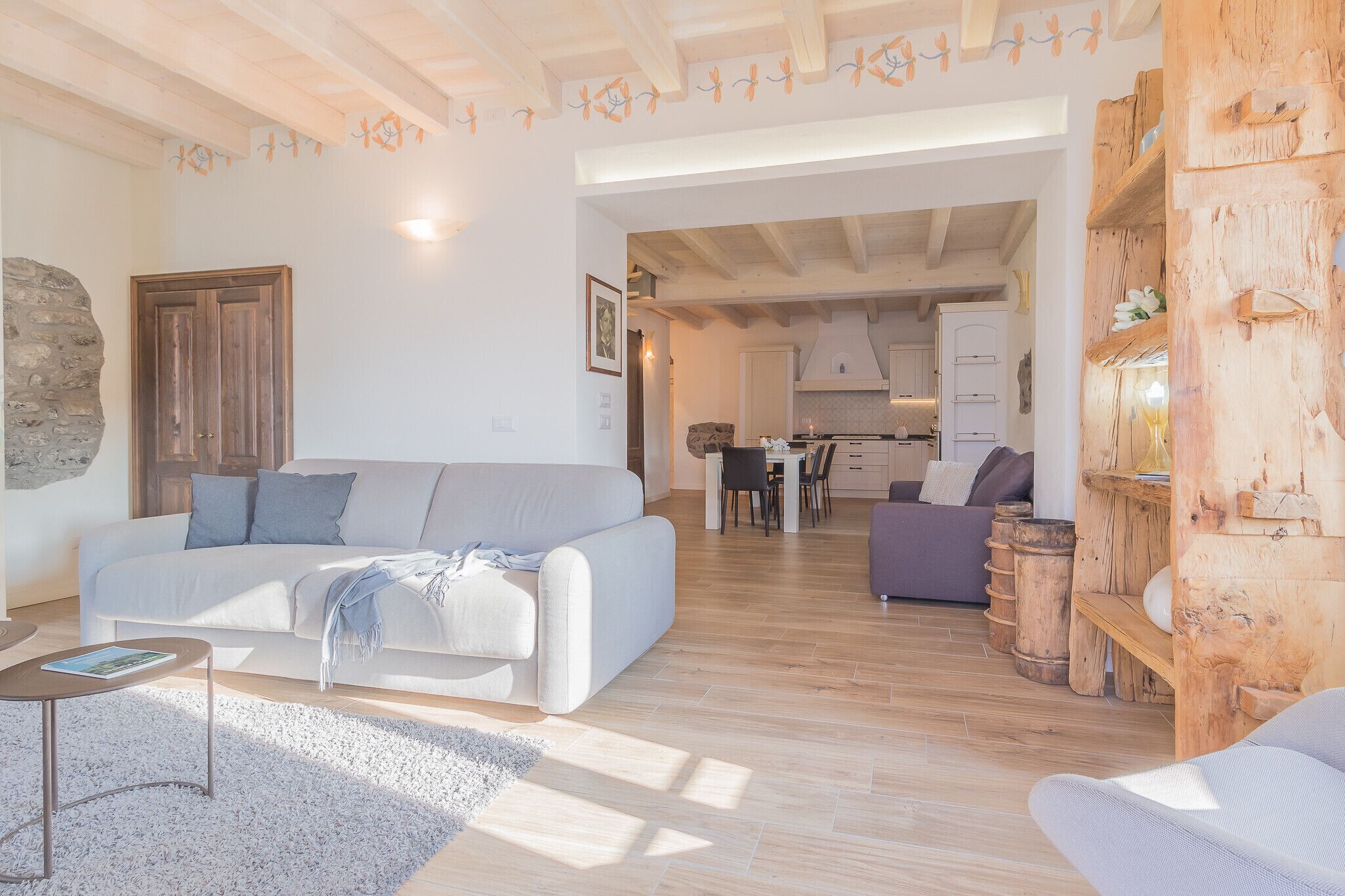 A modern living room with a sofa, a coffee table, and a dining area with chairs and a table.